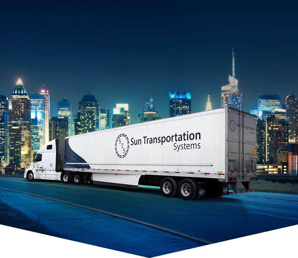 Sun Transportation Systems transport truck driving on highway into a USA city.