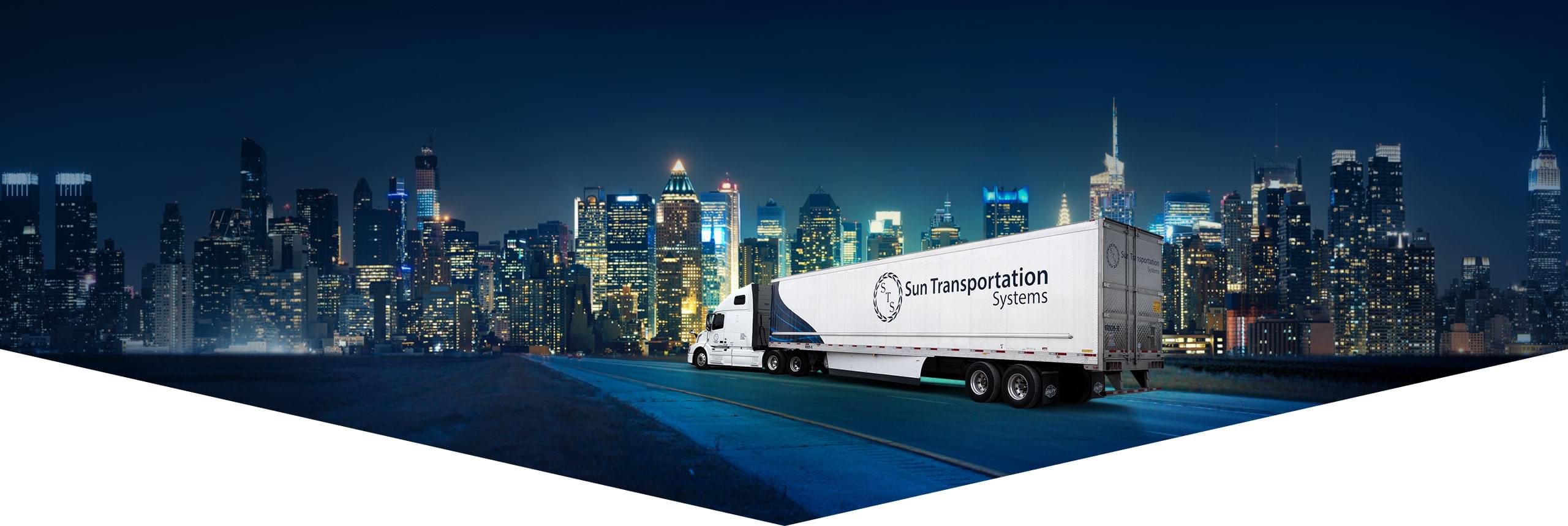 Sun Transportation Systems transport truck driving on highway into a USA city.